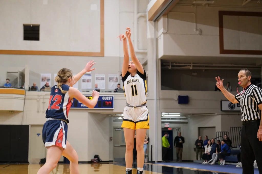 Lucy Xu shoots over a Yale basketball player.