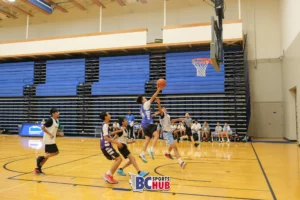 Fundamentals Basketball player rises up for a layup over the outstretched arm of the Showtime Academy defender.
