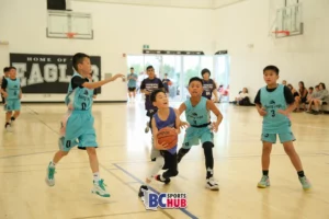 A U10 player from Fundamentals Basketball drives towards the rim.