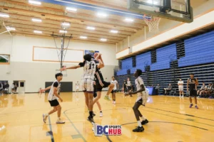#11 from New West Elite blocks the shot of a BC Energy athlete.