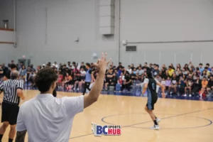 A Showtime Academy Coach raises his hand with the okay hand sign to celebrate a made 3-pointer.
